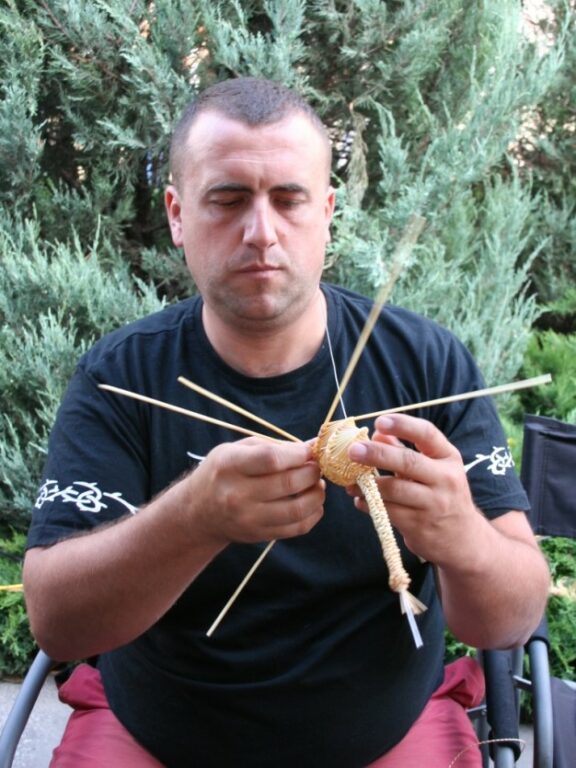 Zobraziť fotografiu Výrobca pri pletení vtáčika zo slamy